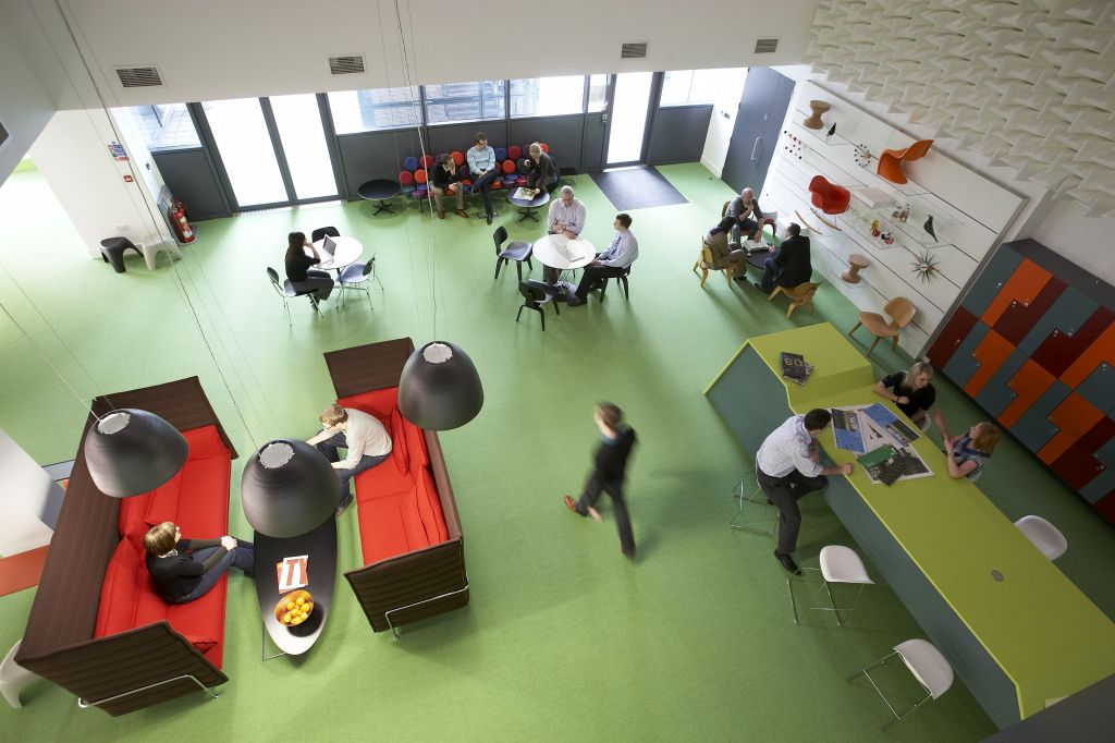 People working and meeting in the bright, colourful Electric Works Club Lounge, seen from above
